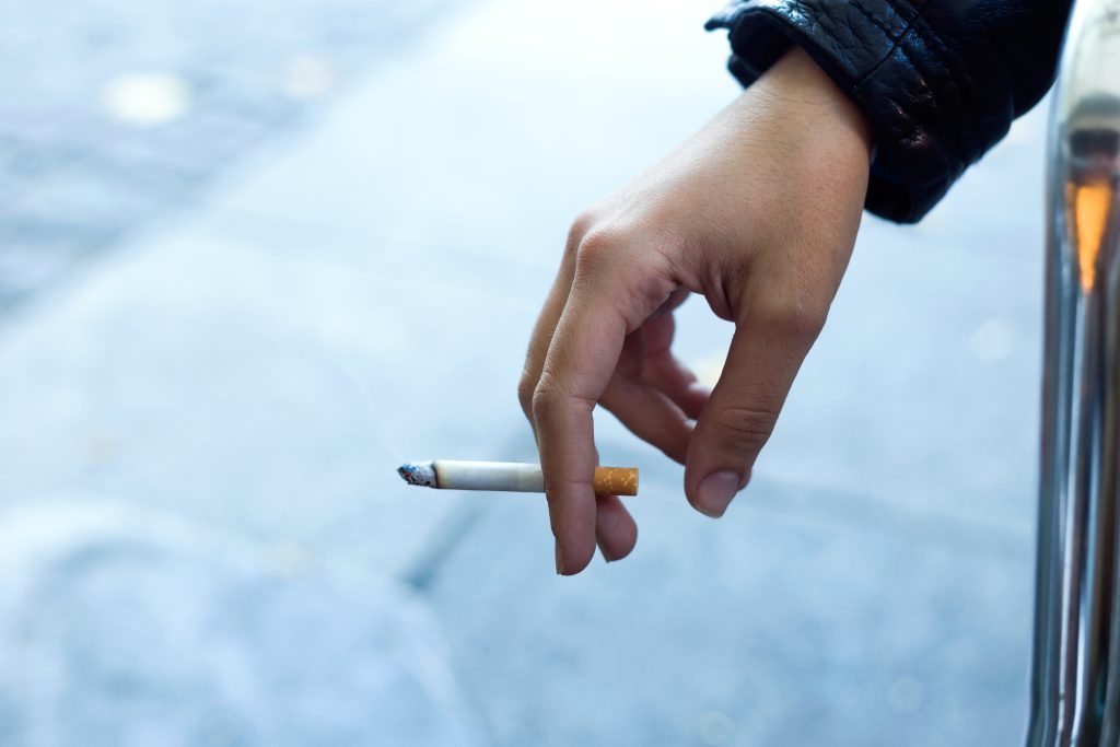 womans hand with cigarette in the street.